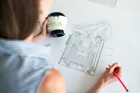 photo d'une ingénieure en train de dessiner le plan d'un robot